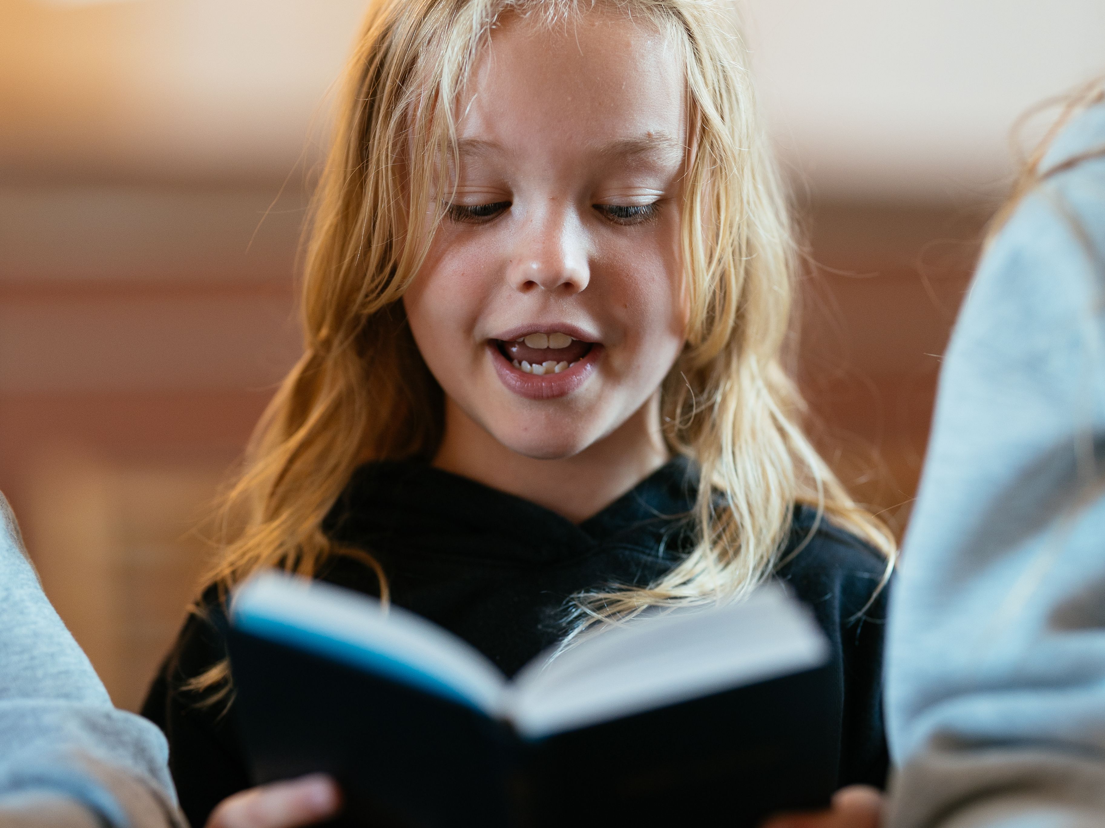 Pige synger og kigger i salmebog