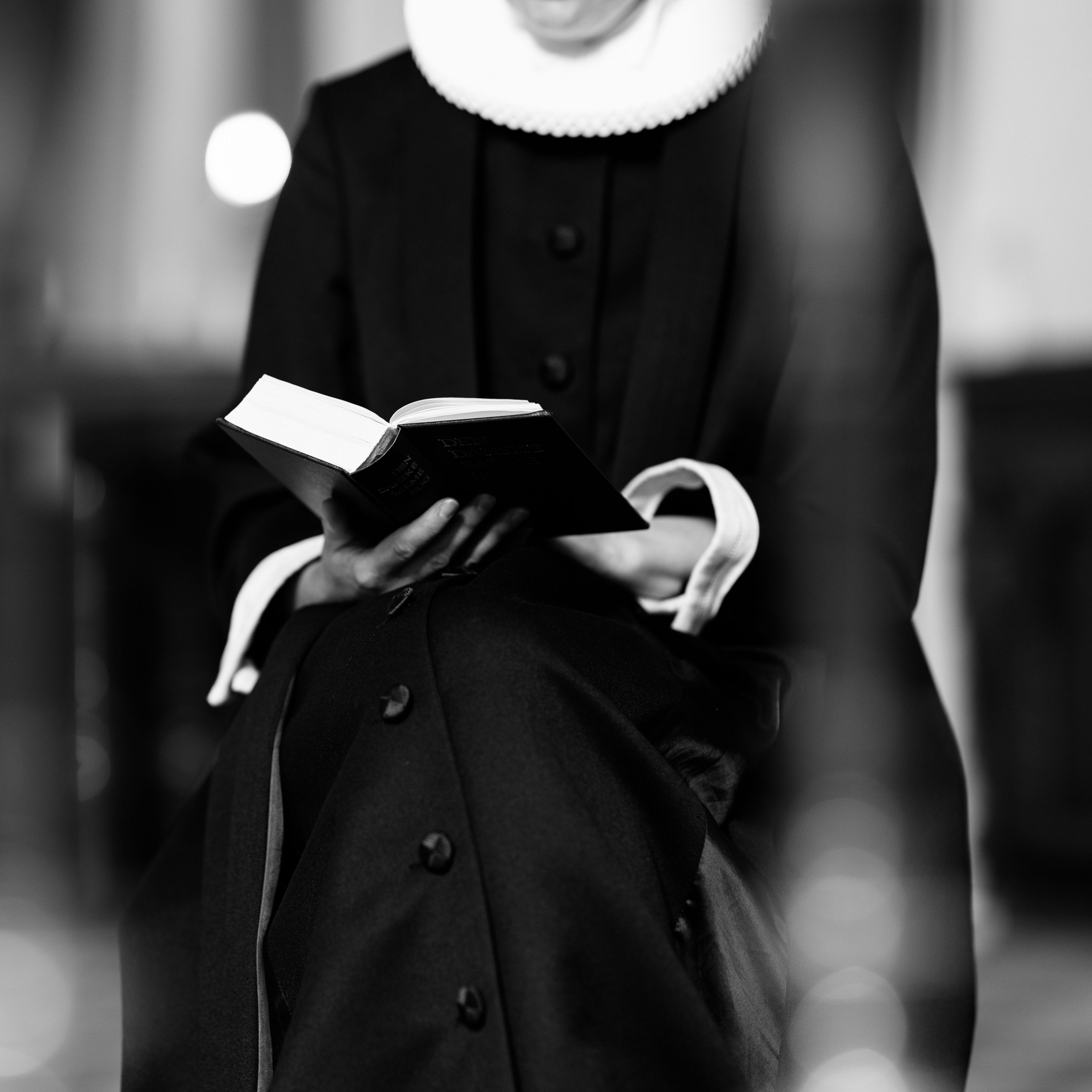 En præst ved alteret med en bibel